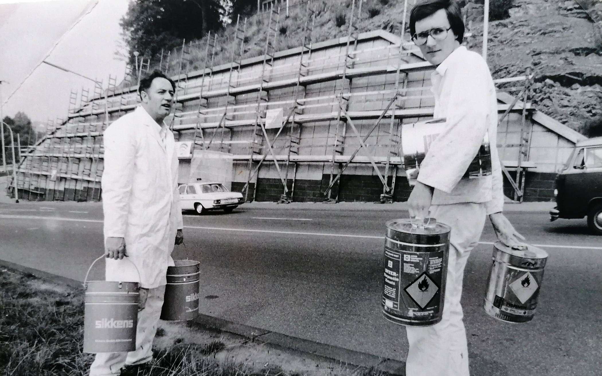  Die Wuppertaler Maler-Meister Helmut (li.) und Detlef Stenzler seinerzeit Ende der 70er Jahre vor dem Start der Bemalung der Stützmauer am Briller Kreuz.  