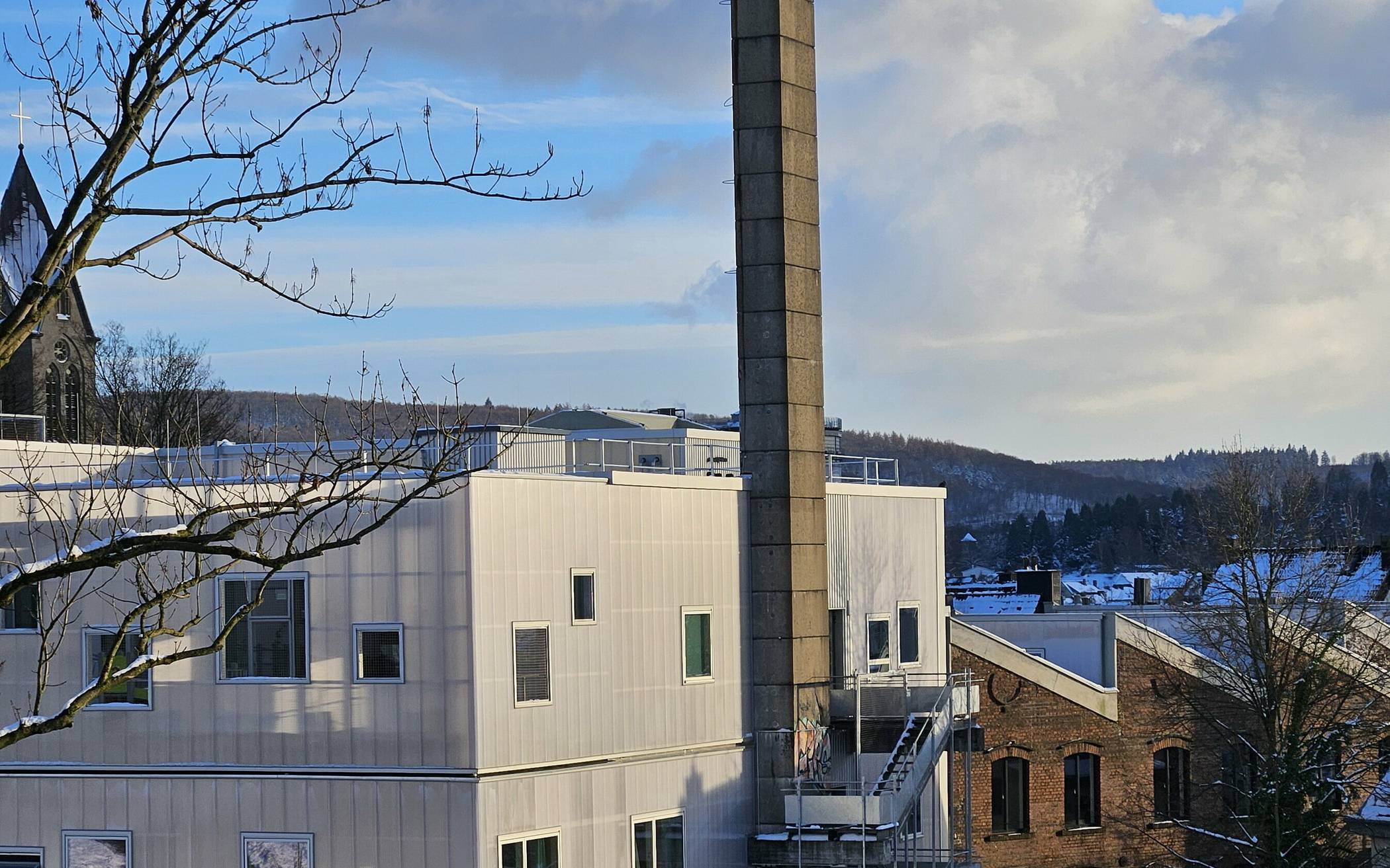 Eine Seitenansicht des BOB-Campus-Gebäudes mit Schornstein.