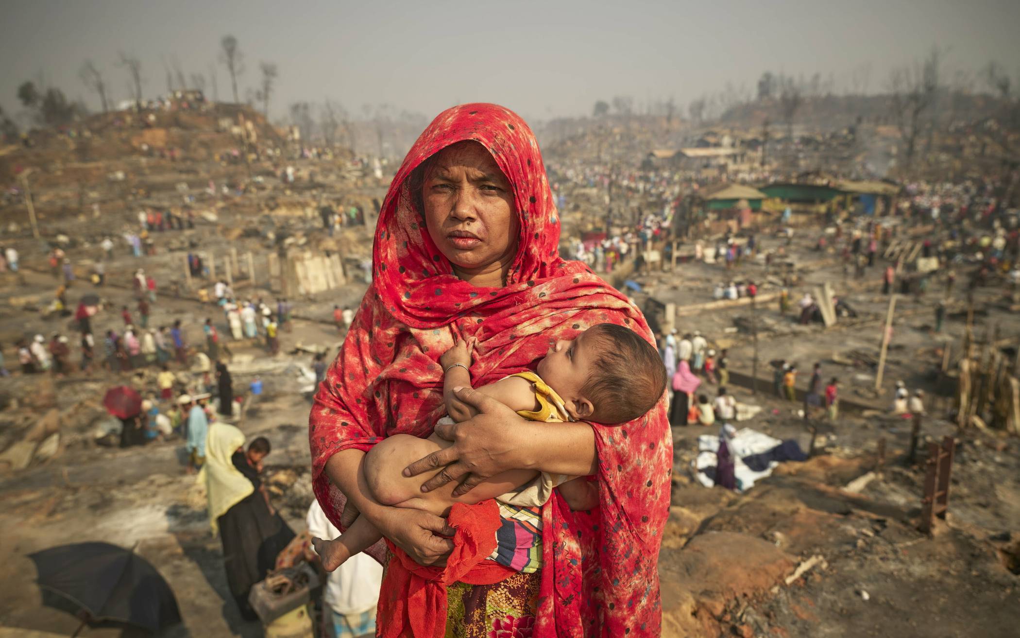 Rohingya vor abgebranntem Ghetto in Bangladesch.