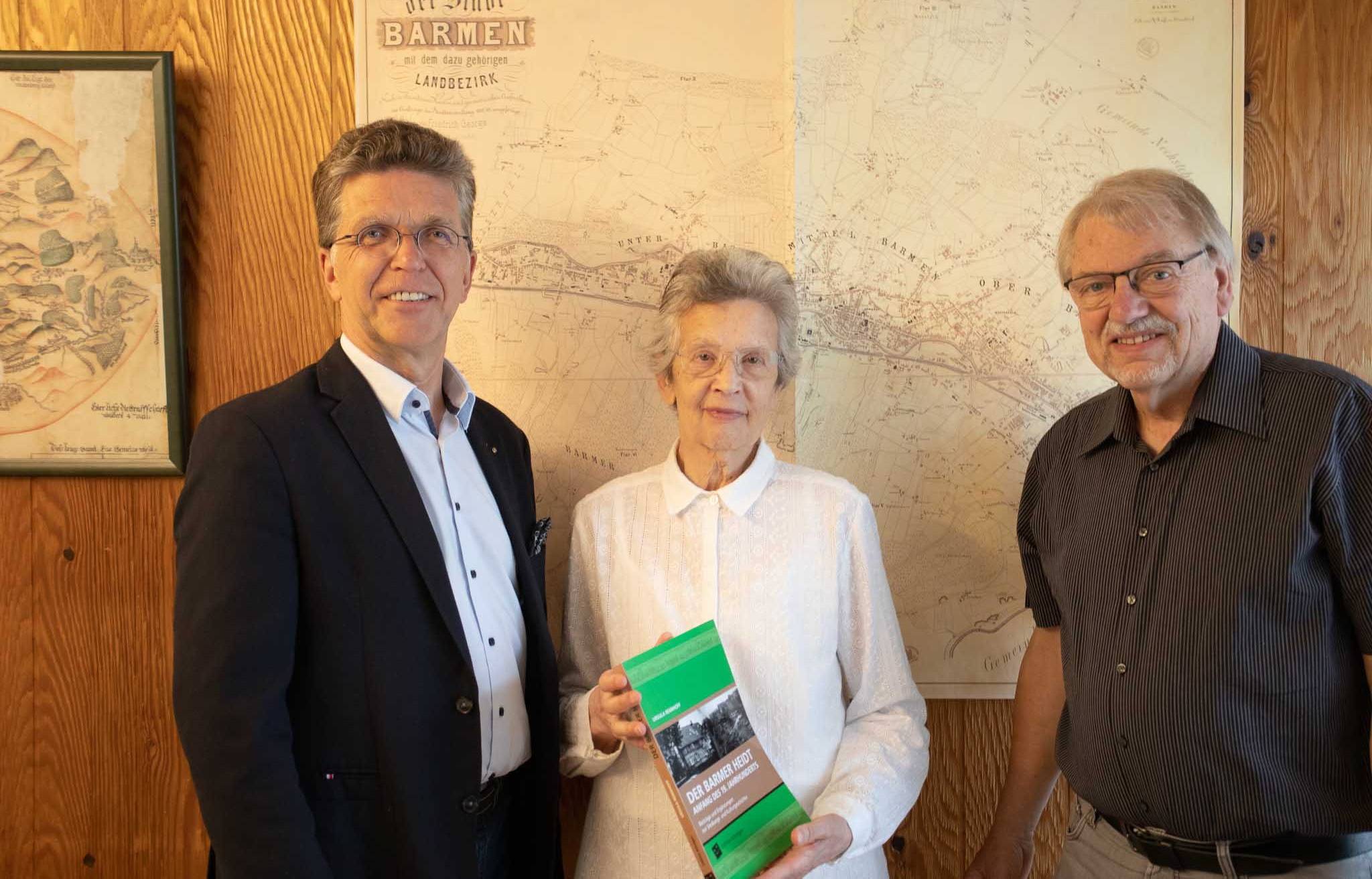  Ursula Rennhoff mit „Edition Köndgen“-Geschäftsführer Thomas Helbig (li.) und Hermann-Josef Brester, dem ersten Vorsitzenden des Heidter Bürgervereins. 