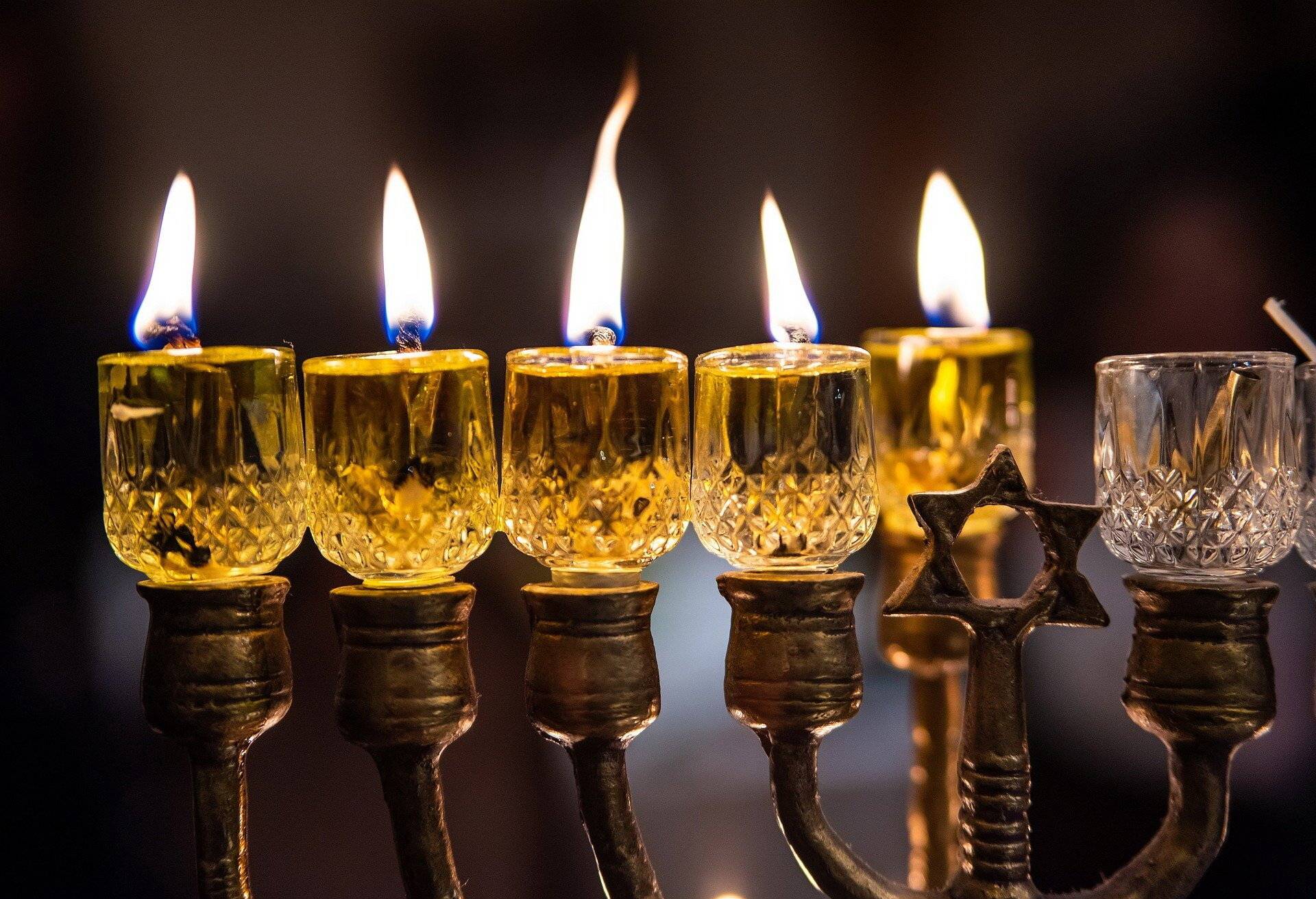 Chanukka-Kerze, Krapfen und Lichtinstallation