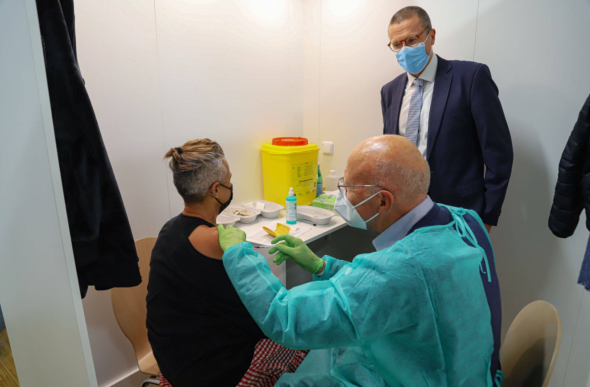  Oberbürgermeister Uwe Schneidewind unterhält sich mit einer Frau, die gerade geimpft wird. 