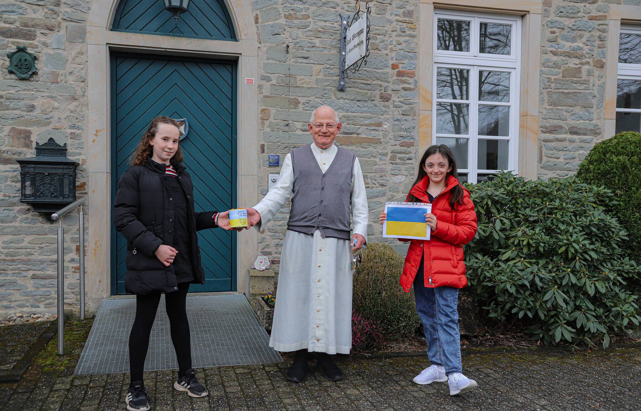  Mia und Lea überreichten die Spendendose an Bruder Dirk vor dem Pfarramt an der Beyenburger Freiheit. 