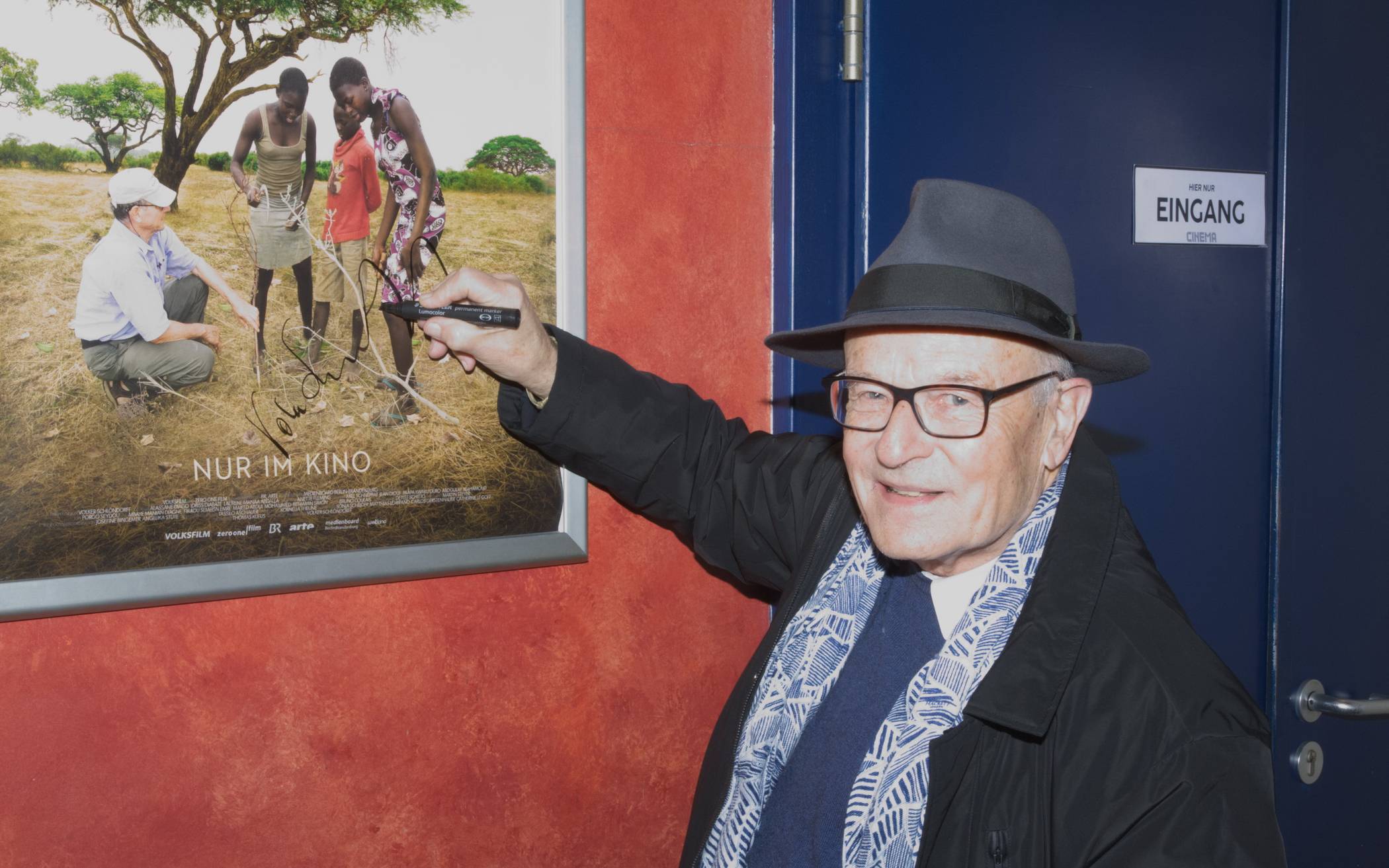  Volker Schlöndorff im „Cinema“ beim Signieren eines „Der Waldmacher“-Filmplakates. 