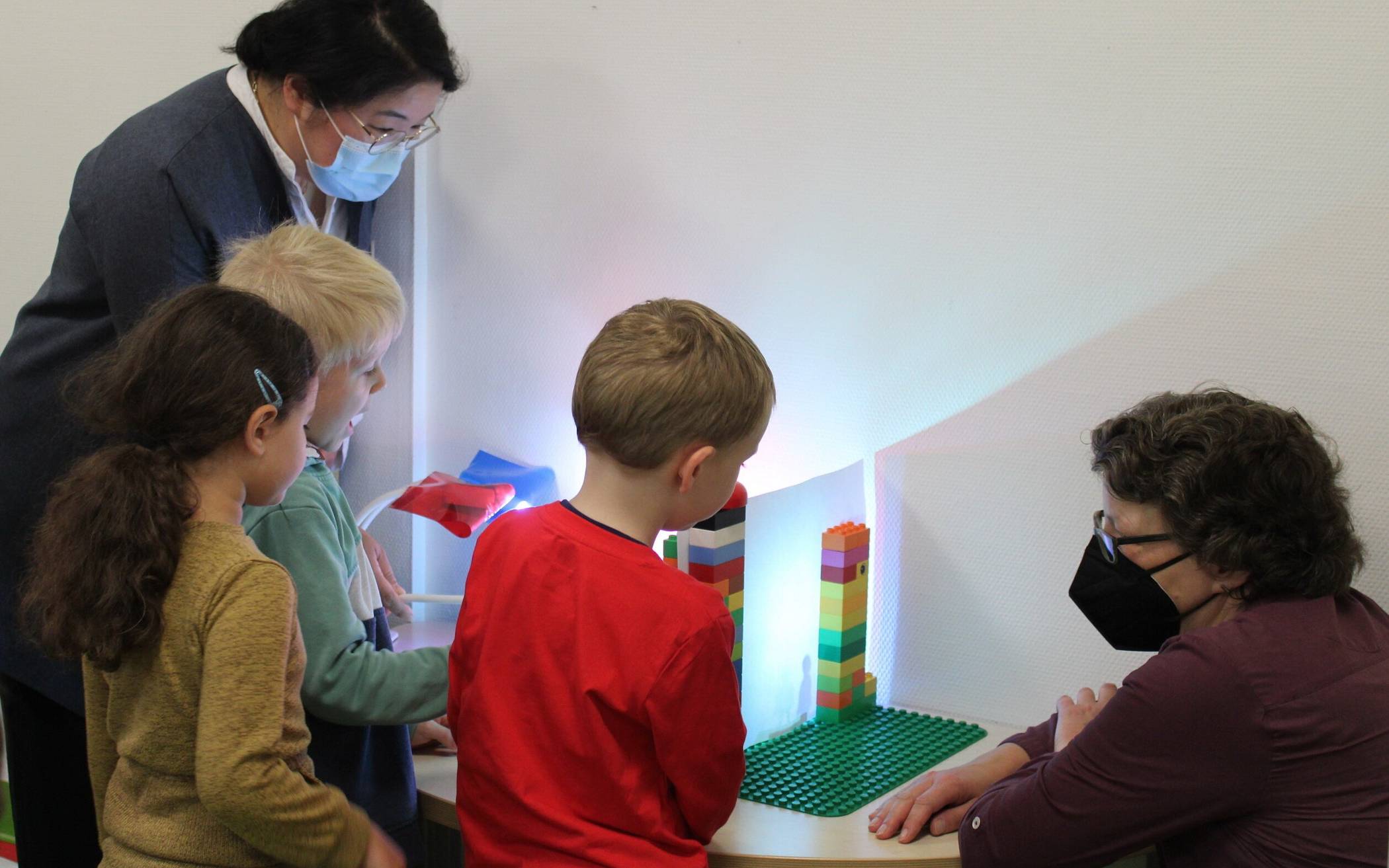  Kinder der Kita „Zaubergarten“ zeigen Simone Hyun (Pflegedirektorin Helios Universitätsklinikum Wuppertal) und Anja Liebert (re.) ihre Experimente. 