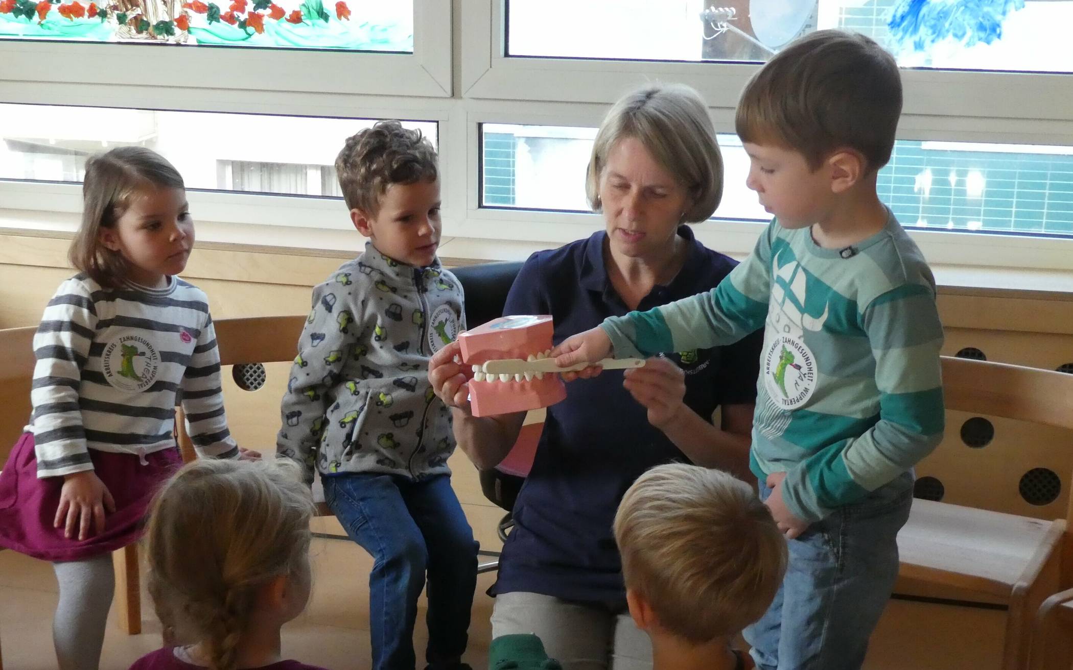Prophylaxe-Expertin Sonja Schmidt mit den Kindern der KiTa Pudelmütze: Mundhygiene ist nicht selbstverständlich und muss spielerisch erlernt werden. 