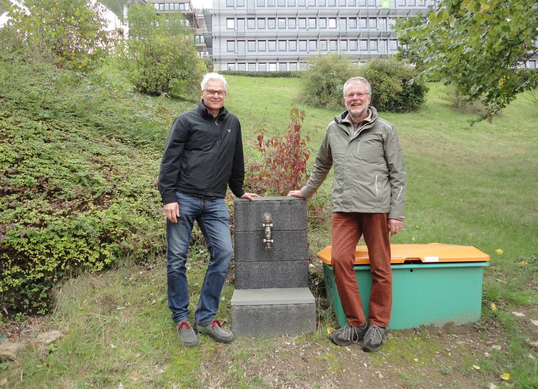  Ulrich Wissemann (re.) und Dr. Roland Kischkel vor der neuen Regenwasserzapfstelle auf dem Campus Grifflenberg. 