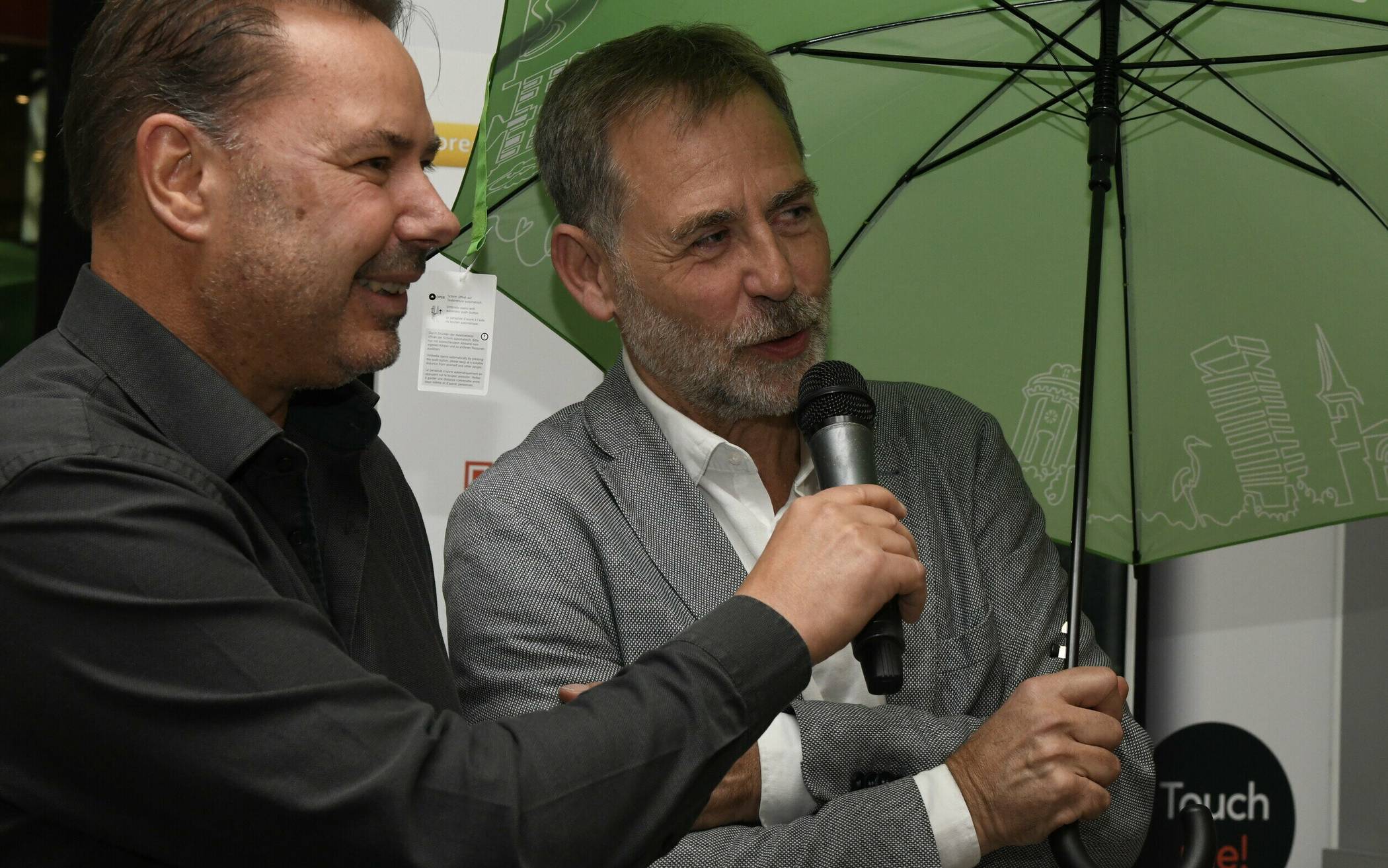 Stadtmarketing-Geschäftsführer Martin Bang  (re., mit Rundschau-Redaktionsleiter Roderich Trapp) stiftete mit Blick auf das Wetter spontan Regenschirme für die Teilnehmer, die beste Wuppertal-Werbung gemacht haben.