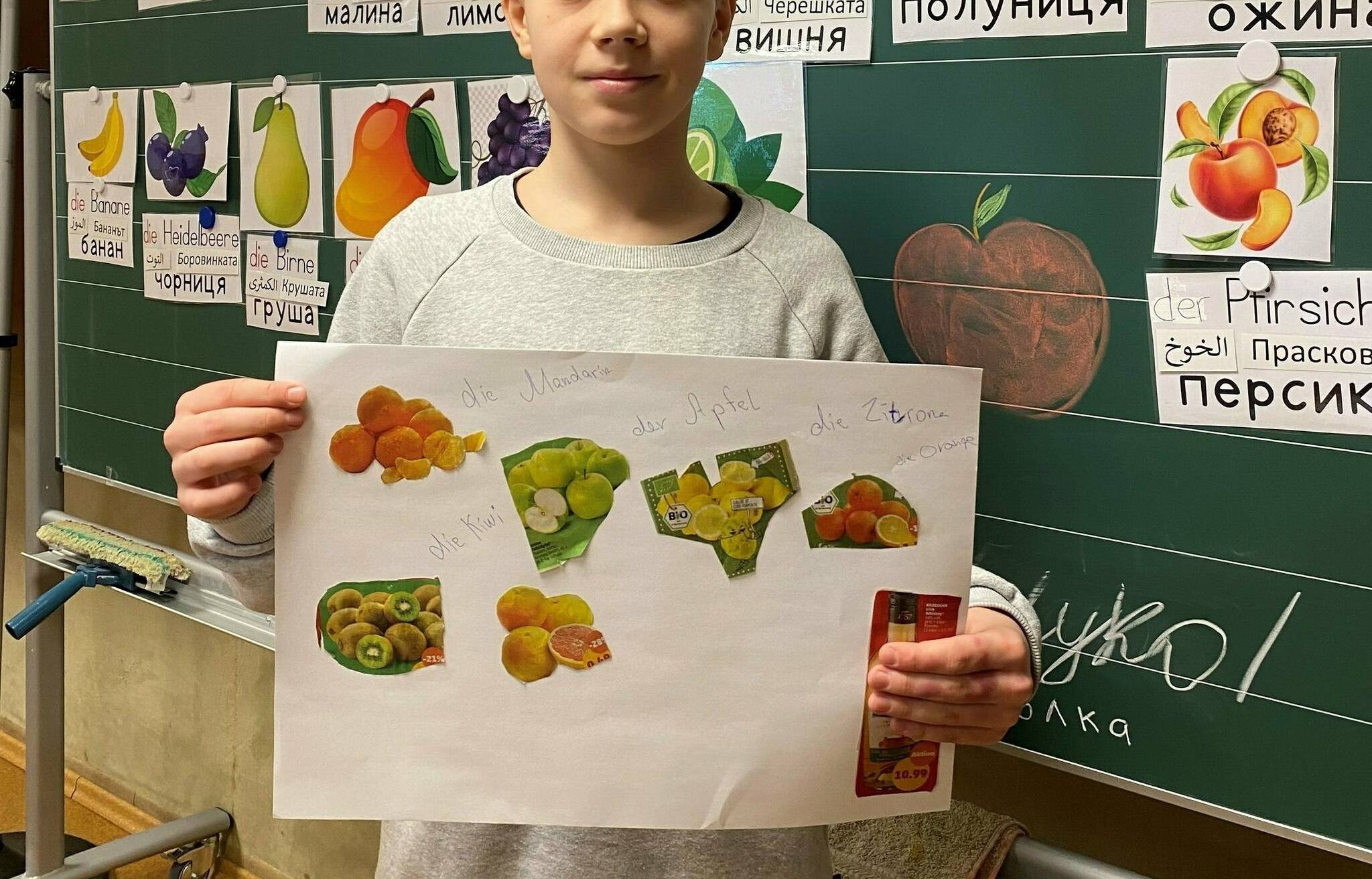  Nikita (13)  zeigt das Plakat mit seinem Lieblingsobst und den deutschen Vokabeln.  