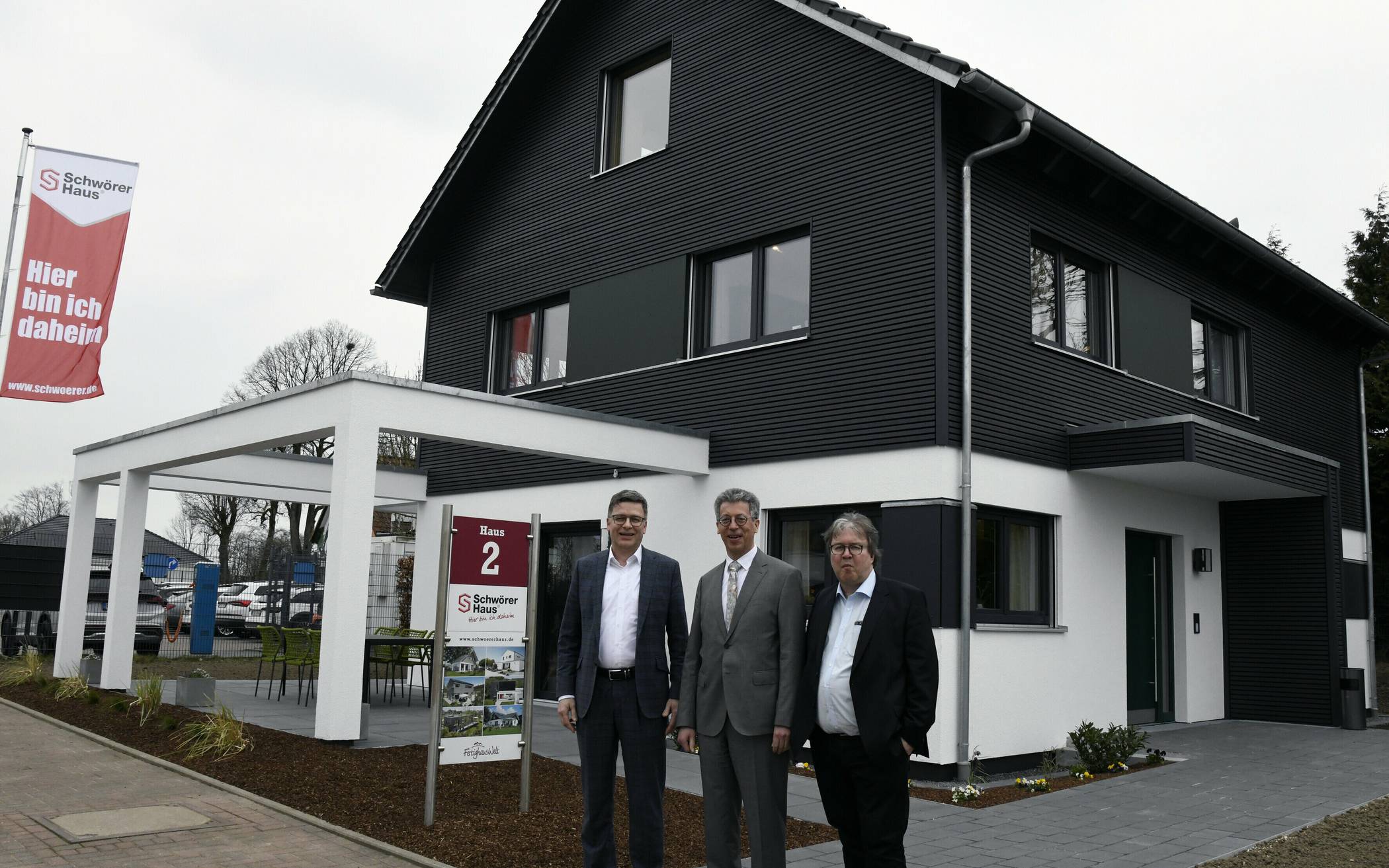 Sie kamen für die Vorstellung des neuen Schwörer-Musterhauses (im Hintergrund) nach Wuppertal: Georg Lange (li.) und Achim Hannott (re.), Geschäftsführer des Bundesverbandes Deutscher Fertigbau, mit Johannes Schwörer (Geschäftsführer von Schwörer-Haus). 