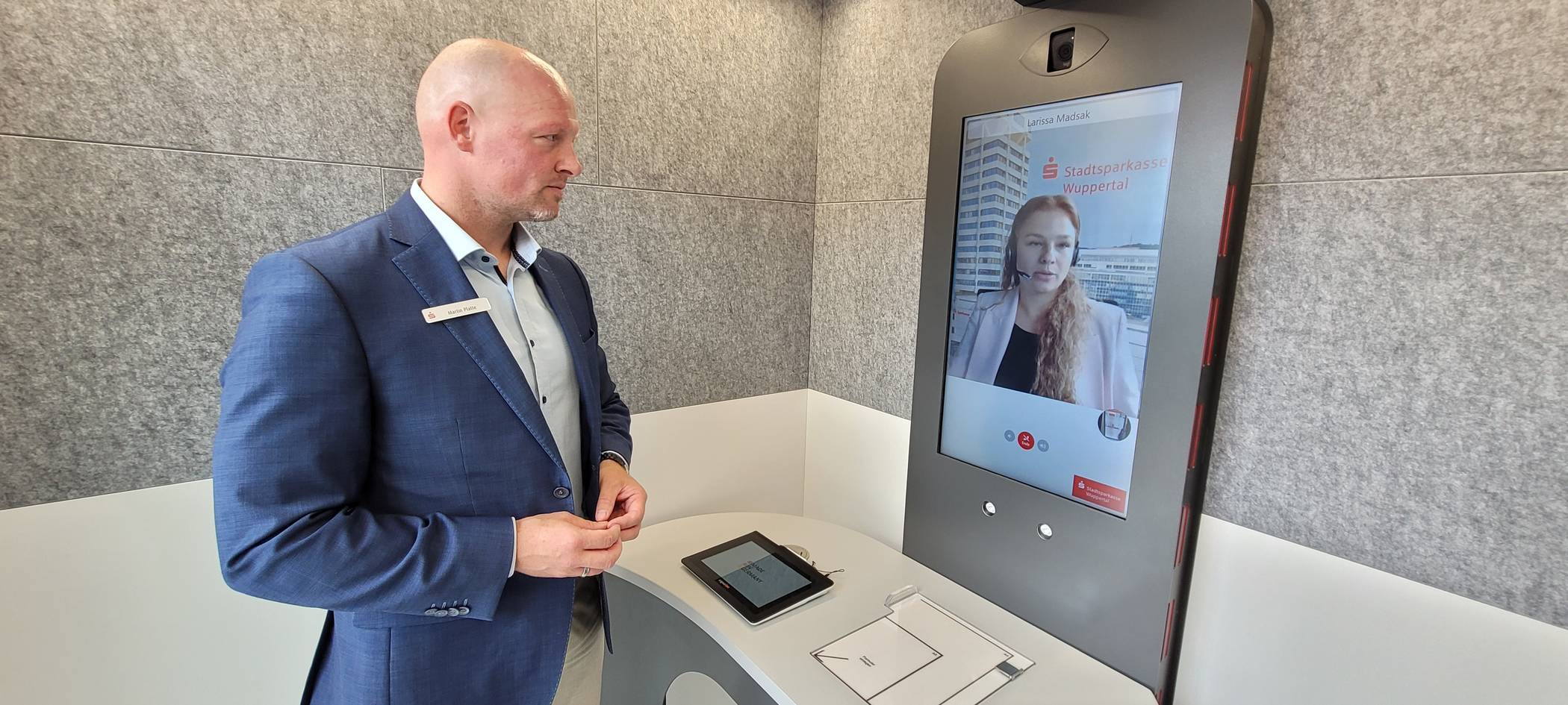  Martin Platt, Regionalleiter West bei der Sparkasse Wuppertal, führt vor, wie sich der Kunde im „Cube“ der Filiale Katernberg fühlt. Im Video-Chat berät ihn Larissa Madsak. 