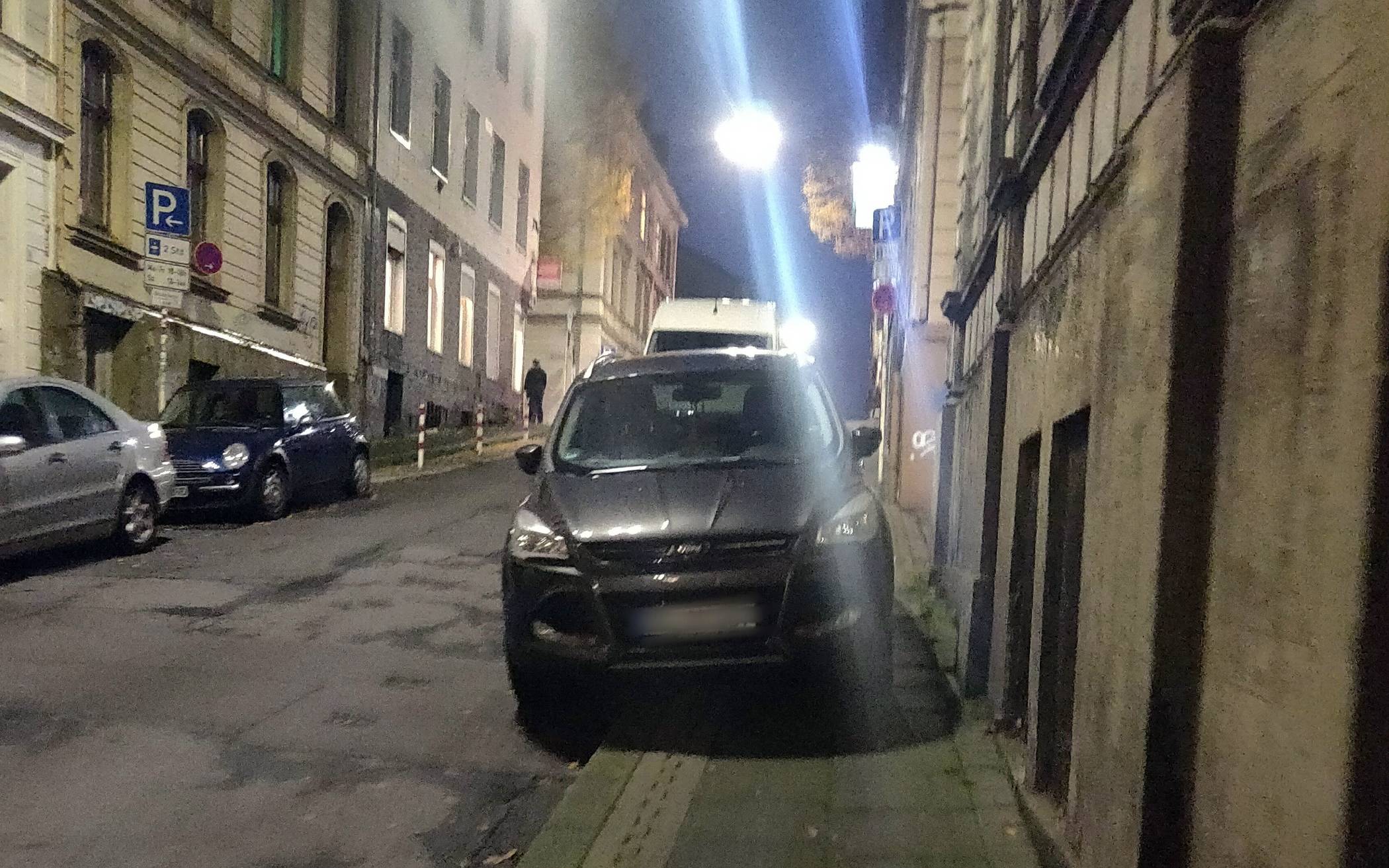 Auf dem Gehweg geparktes Auto in