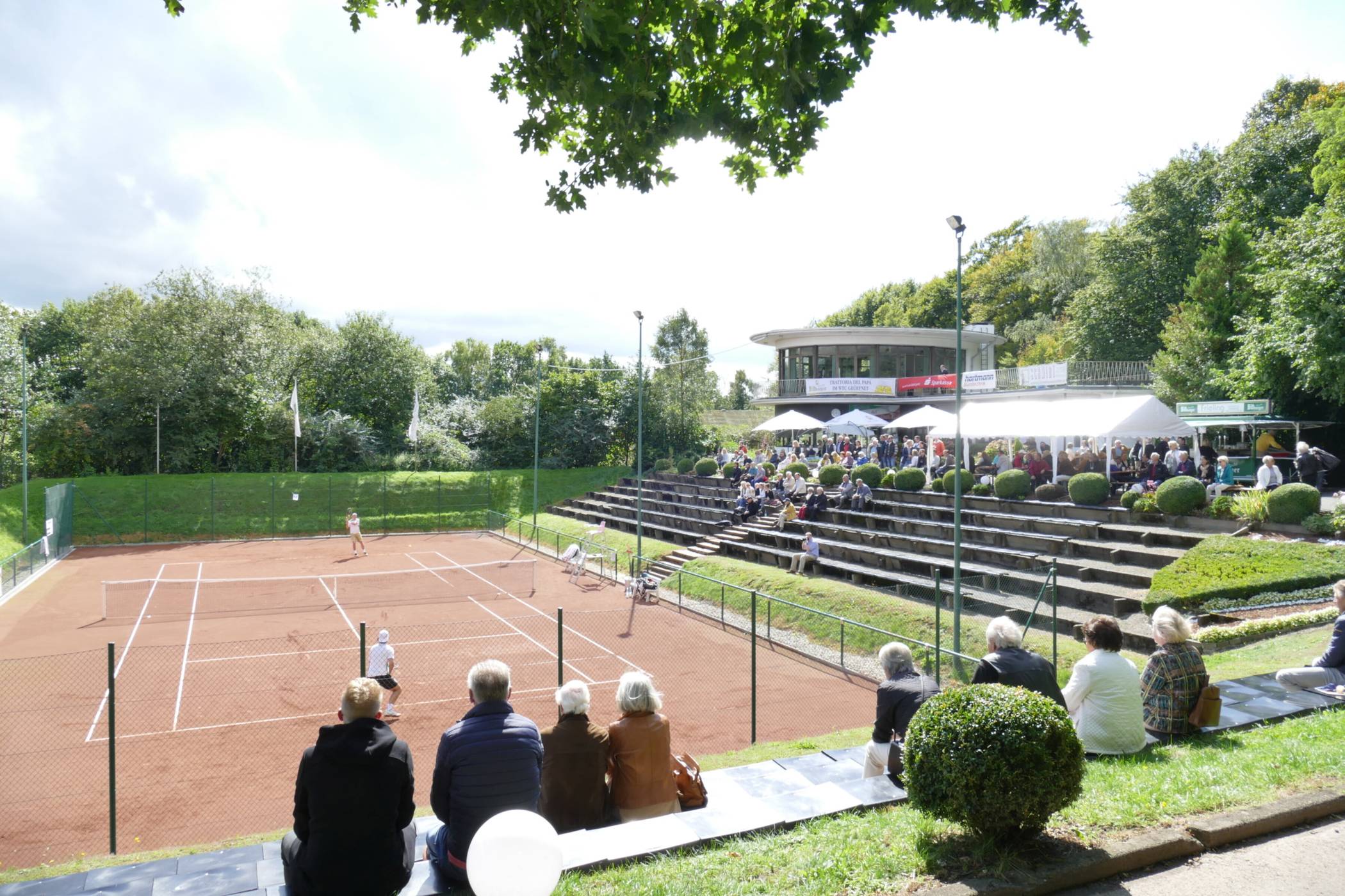  Blick auf einen der sechs Sandplätze und die attraktive Außengastronomie-Terasse des Dönberger Tennisclubs. 