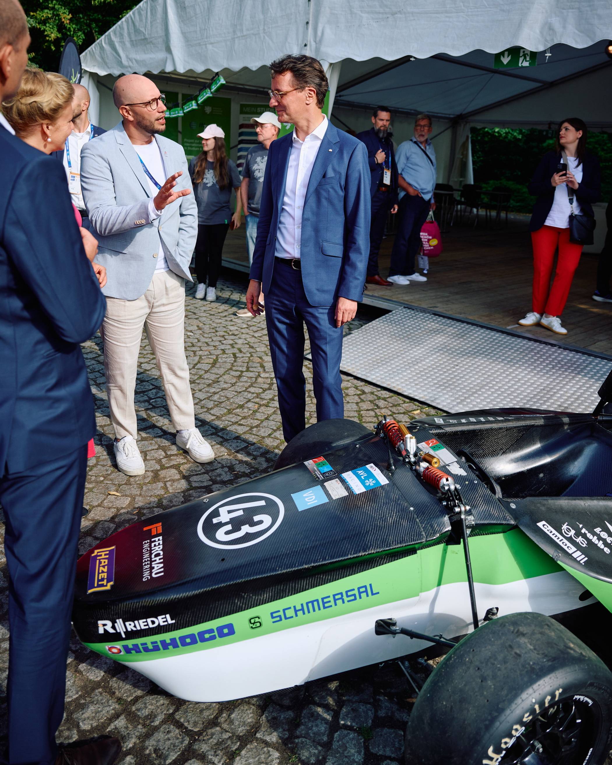 Als eine von nur wenigen Hochschulen nutzte die Bergische Uni in Essen die Gelegenheit, sich zu präsentieren und verschiedene Projekte vorzustellen. So zum Beispiel auch das Green Lion Racing Team, in dem Studierende selbst Rennautos konstruieren und bauen – inzwischen auch als Elektrowagen. Im Gespräch: „UniSport“-Leiter Dennis Fink (li.) und NRW-Ministerpräsident Hendrik Wüst.