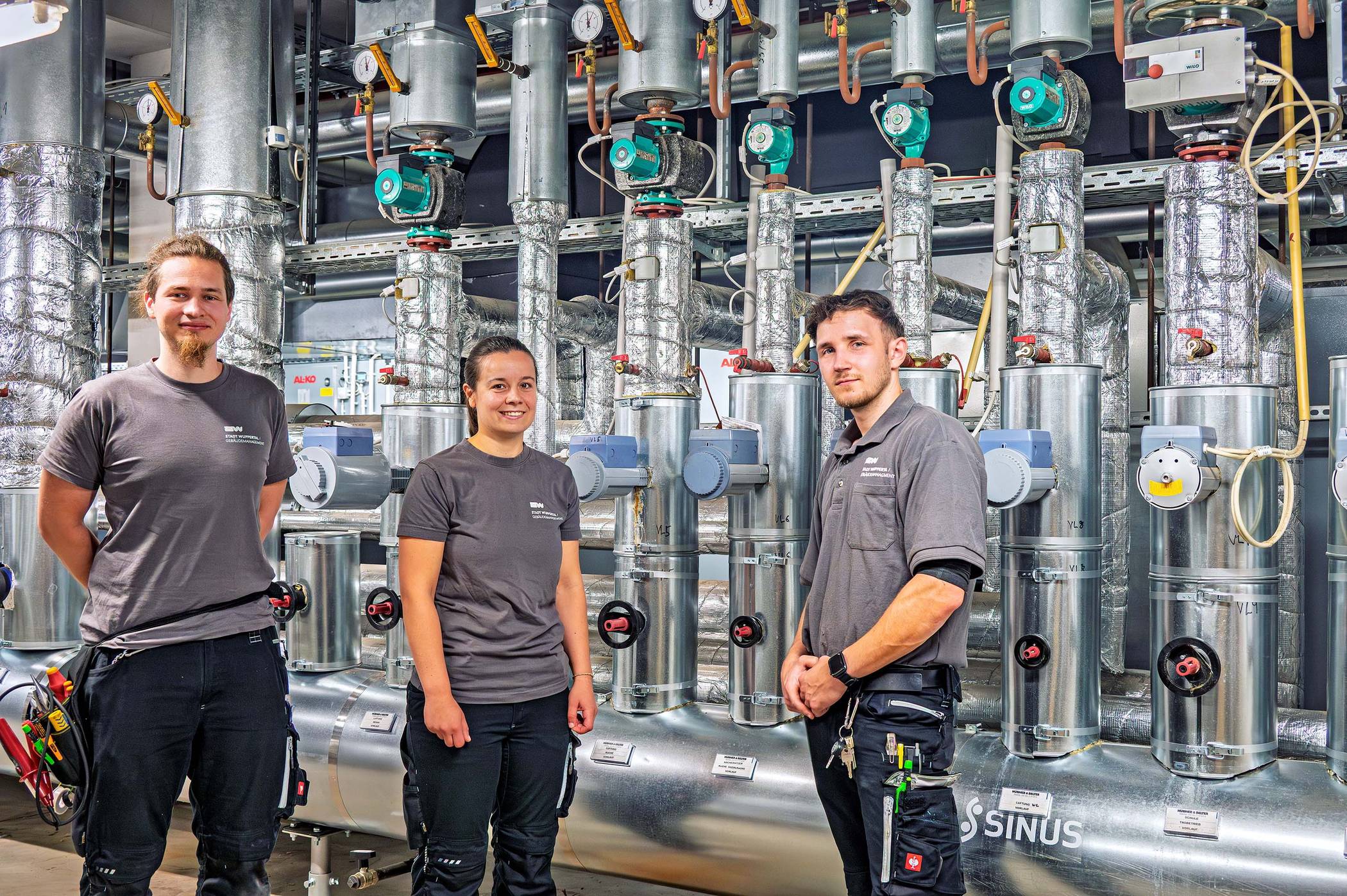 Marcel Weinert, Jana Ress und Claas Pfeiffer (von li.) in der Heizungs- und Lüftungszentrale der Gesamtschule Barmen.