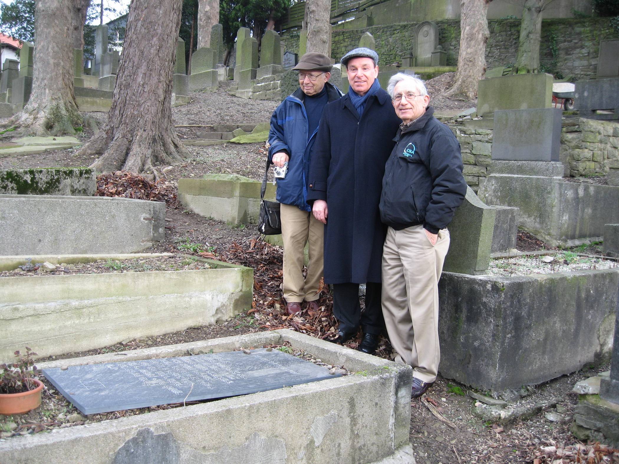 Oswald Laufers Neffen Prof. Dr. Gerd Korman, Dr. Stephen Lawson und Manfred Korman am 13. Januar 2024 am Grab ihres Onkels.