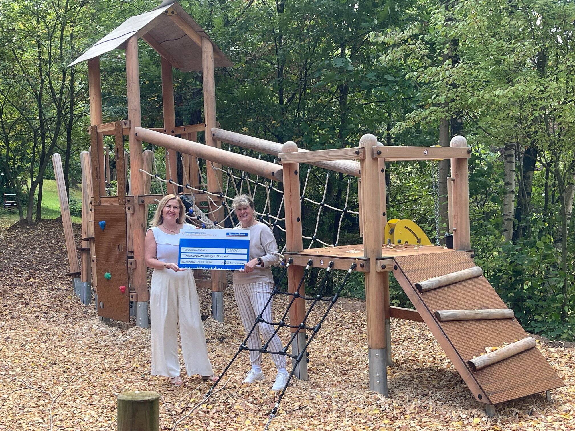Wioletta Bonny (li., Filialleiterin der Sparda-Bank in Wuppertal) überreicht einen symbolischen Scheck an Bettina Thiel (Leiterin des Hochschulkindergartens).