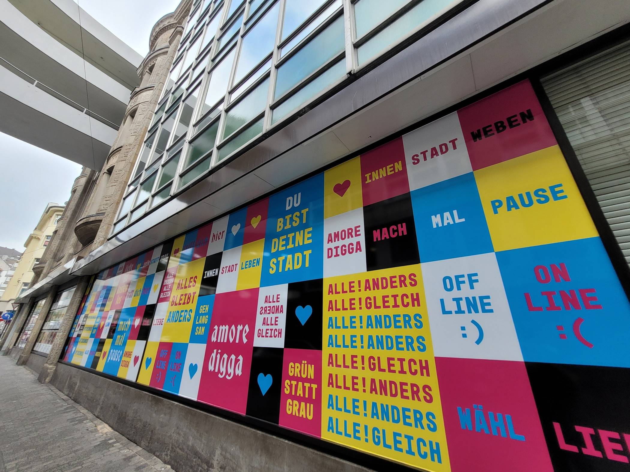 Pink Büchsenschütz hat entlang der Grünstraße eine Fläche mit seinen wort- und farbstarken Plakatmotiven gestaltet.