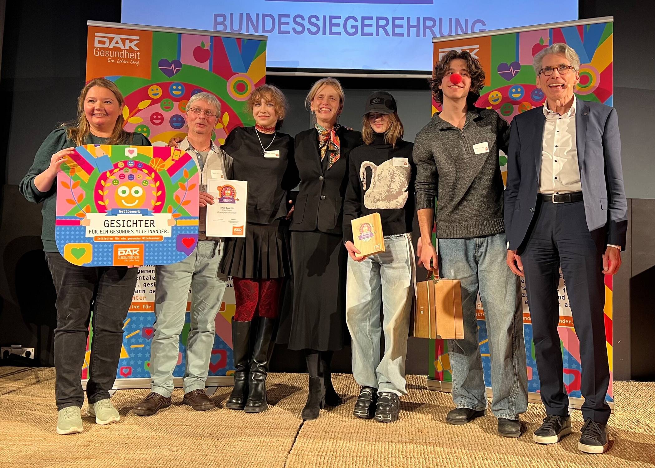  So sehen Sieger aus: Leniie Hafarover, Petris Bartlus, Adriana Haiewa vom Projekt „Clowns gegen Einsamkeit“, Bundesfamilienministerin Karin Prien, Elina Volobuieva sowie Nazar Filianin, ebenfalls von der Aktion – und DAK-Gesundheit-Vorstand Andreas Storm bei der Verleihung 