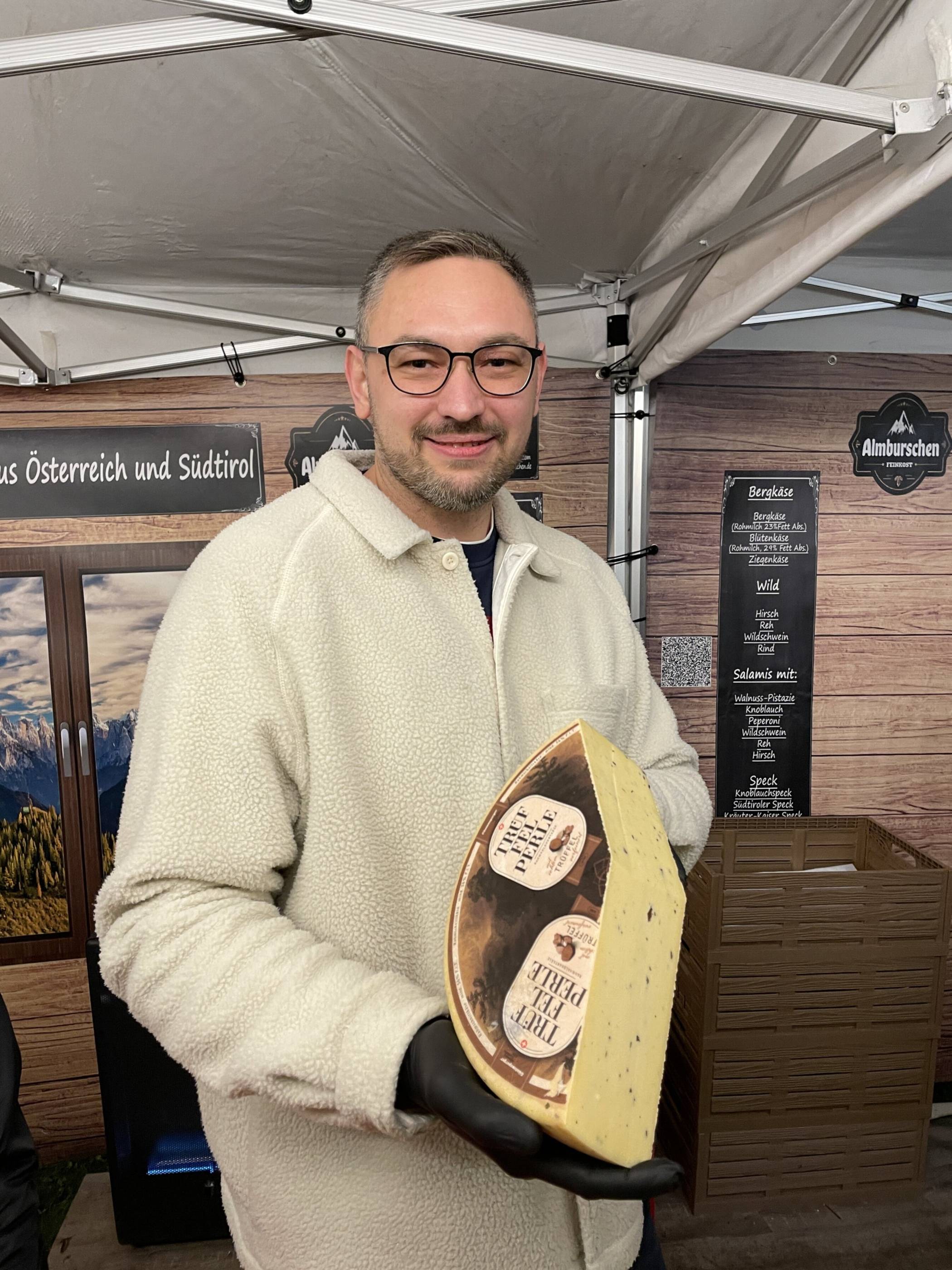 Willi H. aus Wetzlar bietet auf dem Weihnachtsmarkt verschiedene Käsesorten an –...