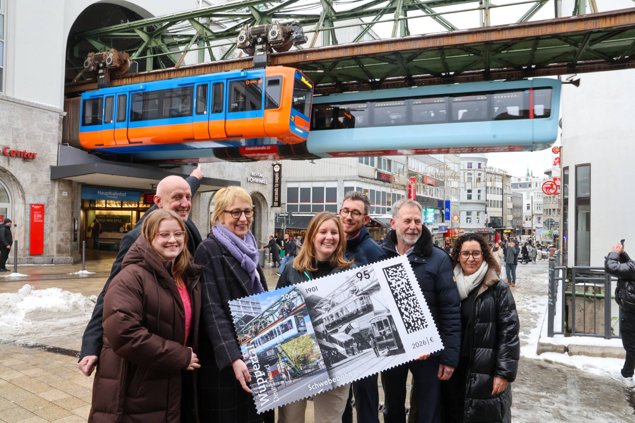 Das Gruppenfoto mit der „alten“ und der aktuellen Schwebebahn – und natürlich der Sonderbriefmarke.