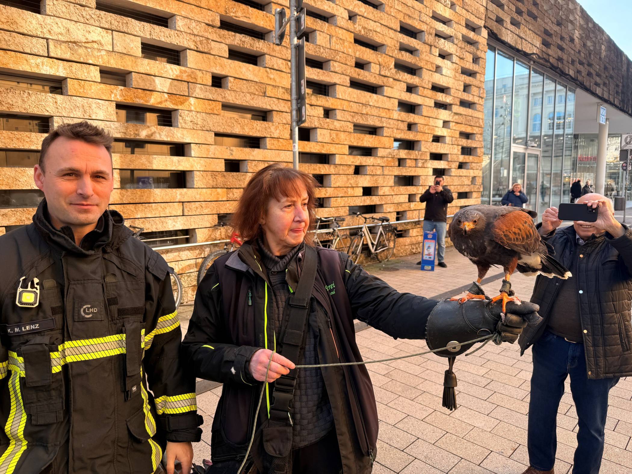 Kevin Lenz von der Feuerwehr Wuppertal mit der Falknerin und dem Wüstenbussard nach dem doppelten Einsatz.