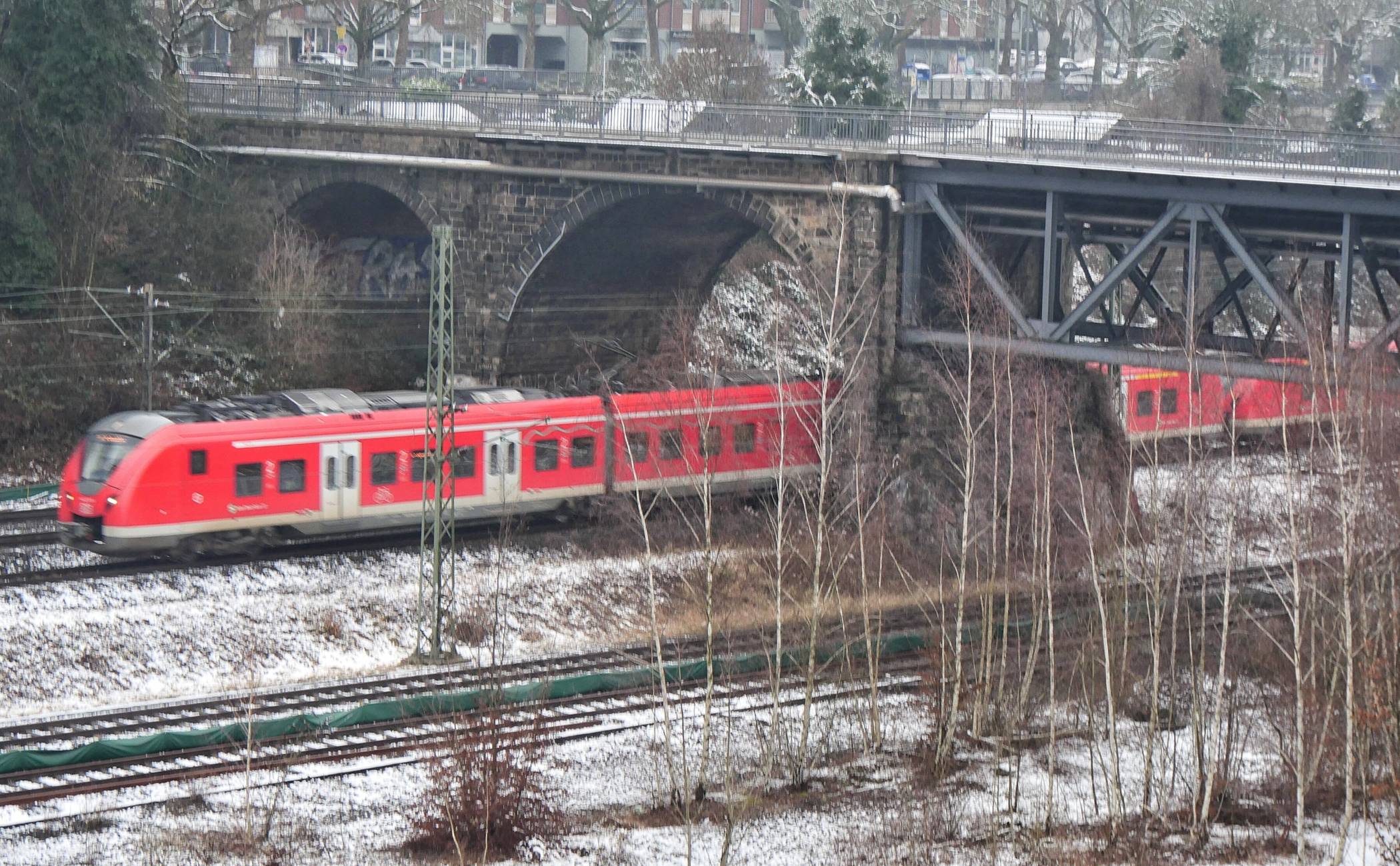 Ein roter Zug in weißer Landschaft.