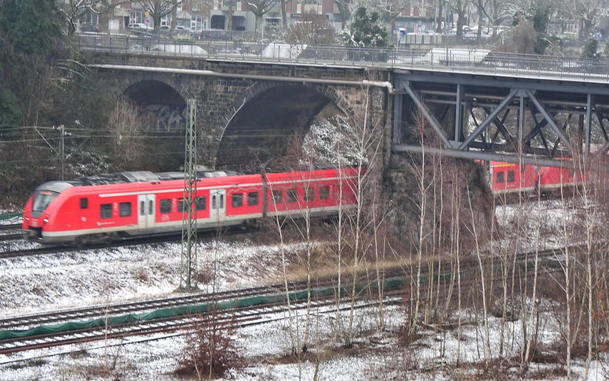 Ein roter Zug in weißer Landschaft.
