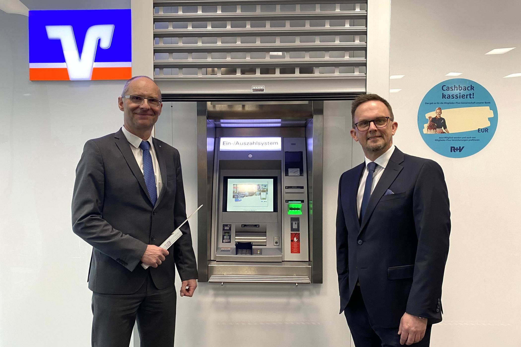  Rollgitter schützen die Geräte nachts vor unbefugtem Zugriff: Vorstand Christian Fried (re.) und Architekt Andreas Bona stellten die Sicherungsmaßnahmen im April 2024 vor. Die neuen Farbkassetten im Inneren sind für die Nutzerinnen und Nutzer nicht sichtbar. 