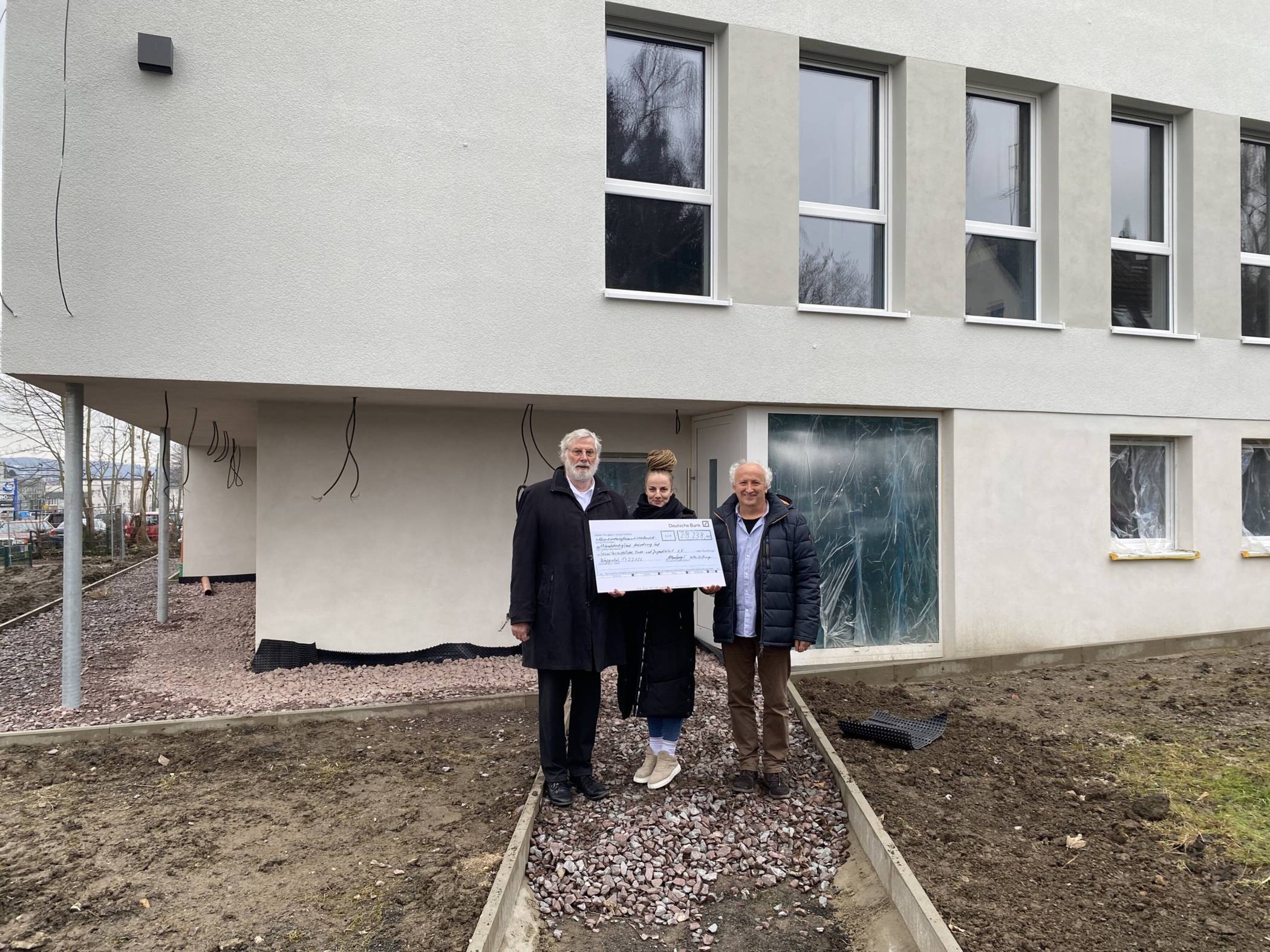  Symbolische Spendenscheck-Übergabe auf der Baustelle des zukünftigen Gebäudes für „Systemsprenger“-Jugendliche: Dr. Martin Hamburger, Vorstandsmitglied der Bethe-Stiftung (links), zusammen mit Isabel Walzberg und Marko Golub vom SKF. 