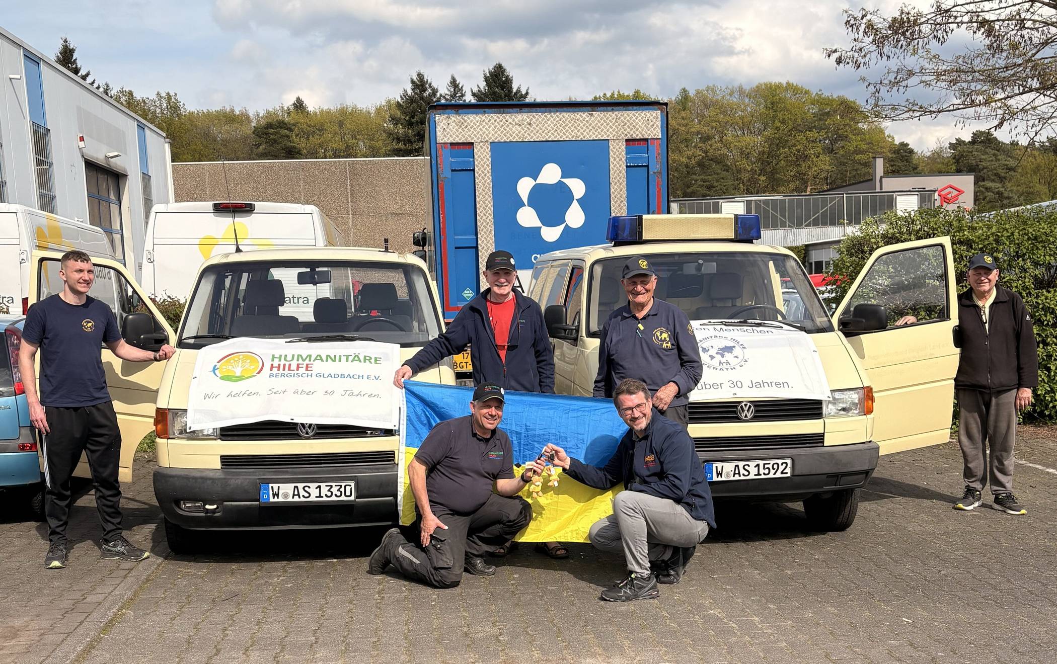 ASB-Geschäftsführer Dennis Bracht (vorne re.) bei der Übergabe an Ulrich Gürster (vorne li., Vorsitzender der Humanitären Hilfe Bergisch Gladbach) und Norbert Kuhl (Vorsitzender der Humanitären Hilfe Overath, stehend re.).