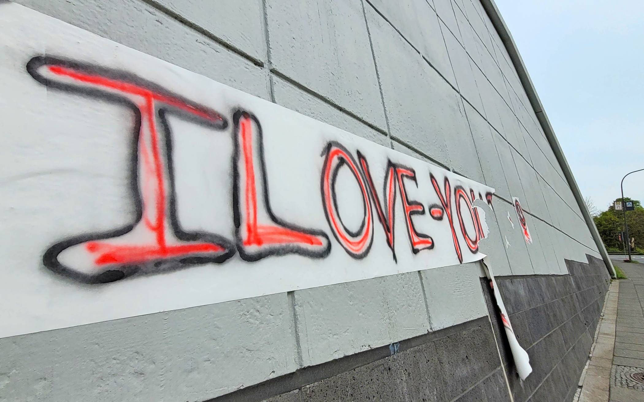 Im unteren Bereich der Wand am Briller Kreuz gibt's auch eine „I Love You“-Botschaft auf geklebtem Papier.