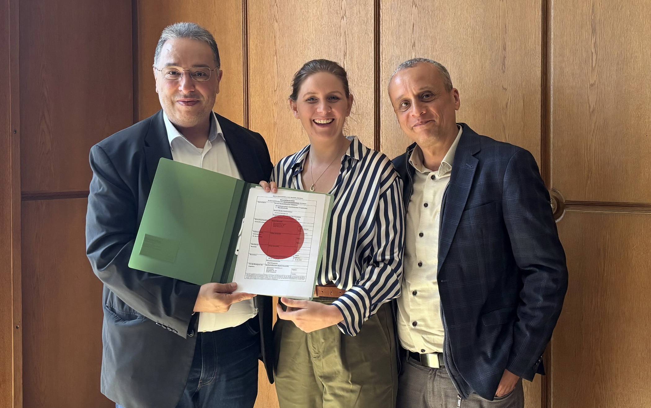  Die Übergabe der Baugenehmigung durch Oberbürgermeisterin Miriam Scherff an Samir Bouaissa (li., Vorsitzender des Trägervereins) und Mohamed Abodahabm (Vorstandsmitglied der islamischen  Gemeinde Wuppertal). 