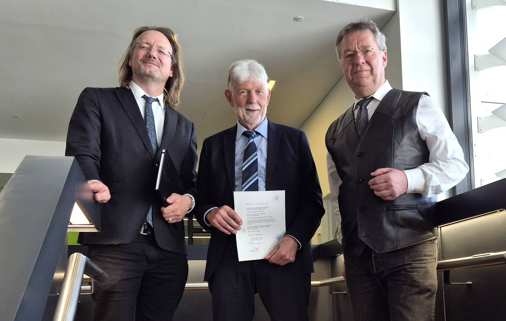 Im Beisein von Promotionsbetreuer Prof. Stefan Bracke (li.) überreichte der Dekan der Fakultät für Maschinenbau und Sicherheitstechnik, Prof. Eberhard Schmidt (re.), die Promotionsurkunde an Dr. Franz-Georg Neupert.