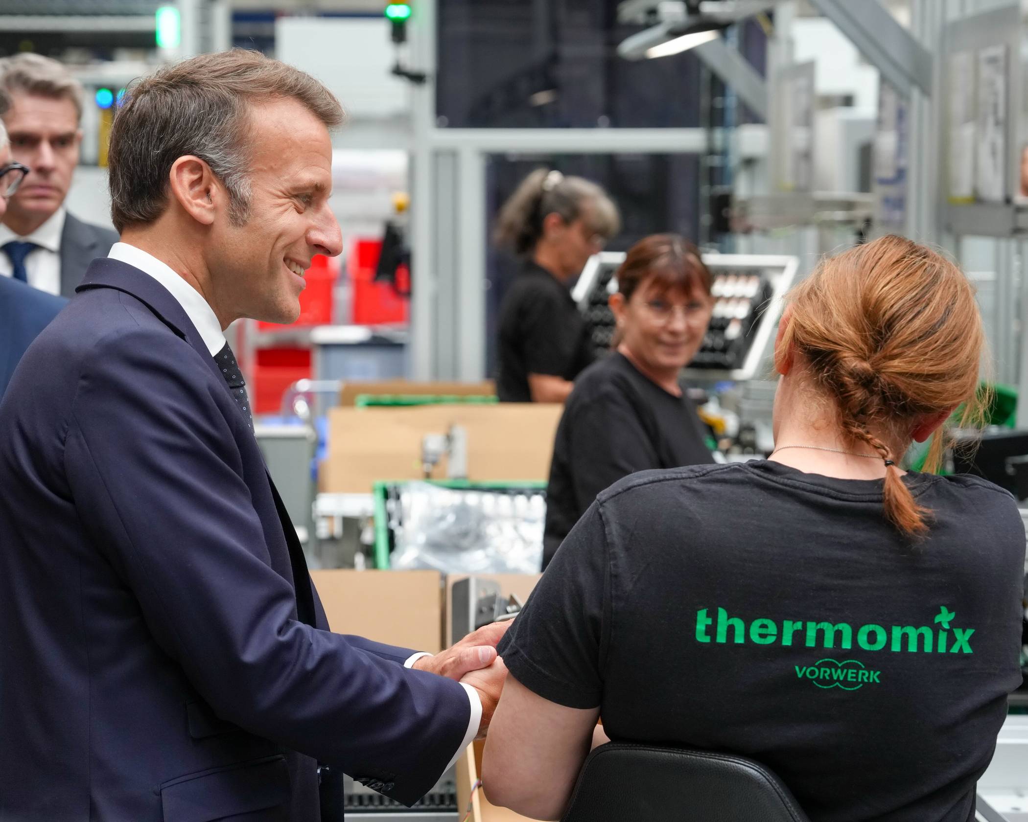 Emmanuel Macron im Gepräch mit einer Mitarbeiterin.