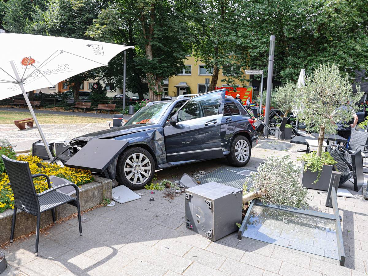 Auto fährt durch Außengastronomie