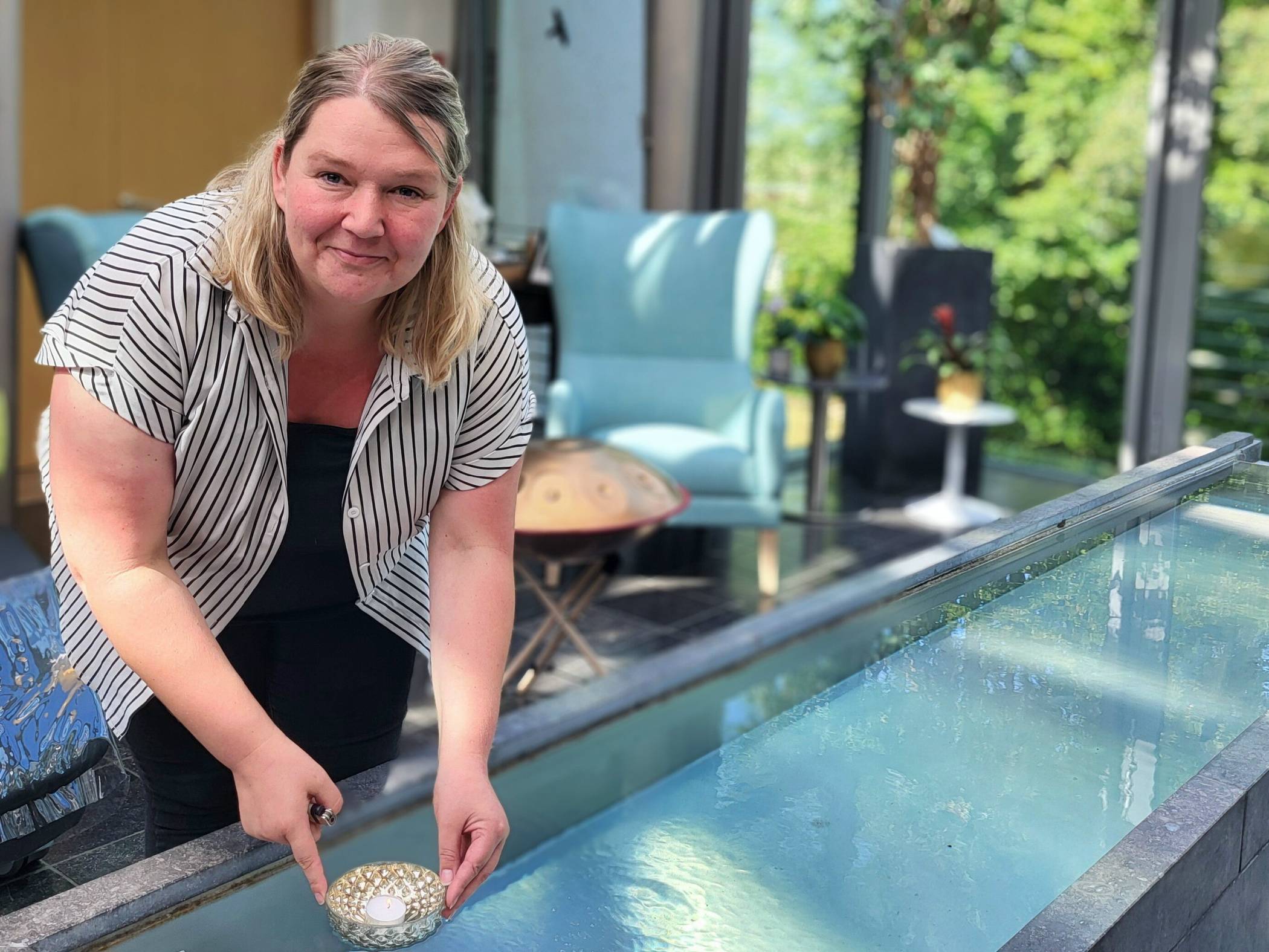 Ann-Christin Günther, Leiterin des Hospizes am Dönberg, lässt eine Kerze in der „Halle des Lichts“ schwimmen.