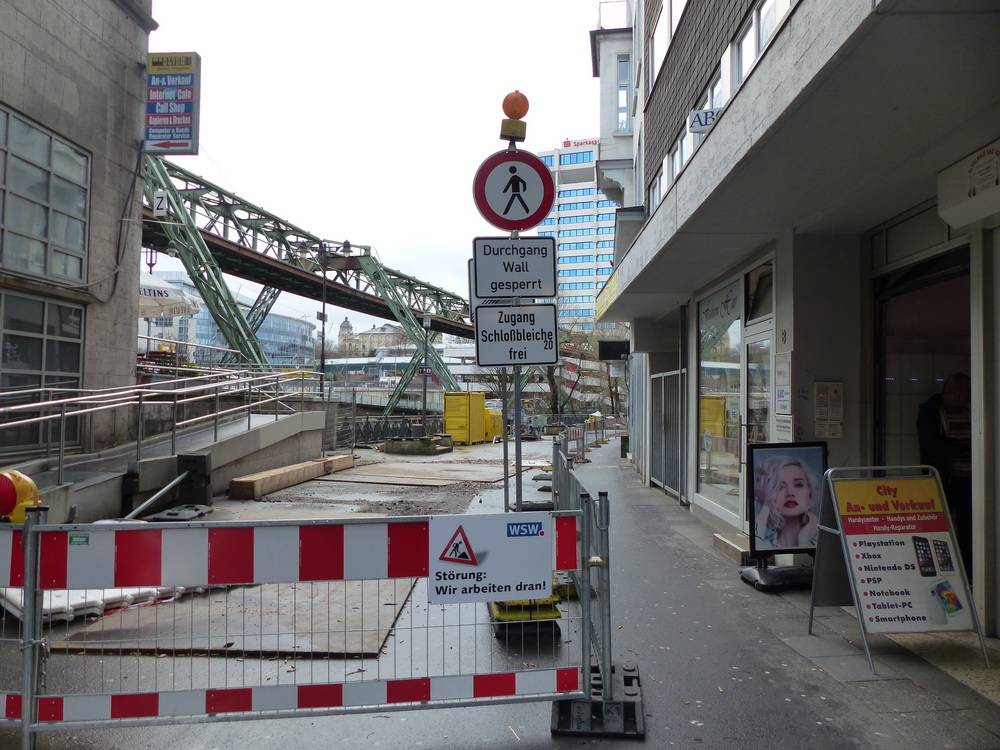  „Durchgang Wall gesperrt, Zugang Schloßbleiche frei“ sagen die Schilder neben der Schwebebahnstation, trotzdem verirren sich nur weniger Fußgänger zu den Läden auf der Schloßbleiche. 