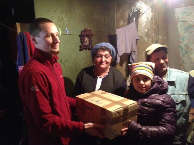  Übergabe eines Lebensmittel-Paketes an eine bedürftige Familie in Heltau (2015). 