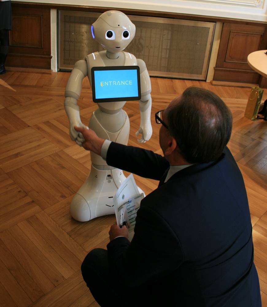  Oberbürgermeister Andreas Mucke schüttelt Pepper die Hand. 