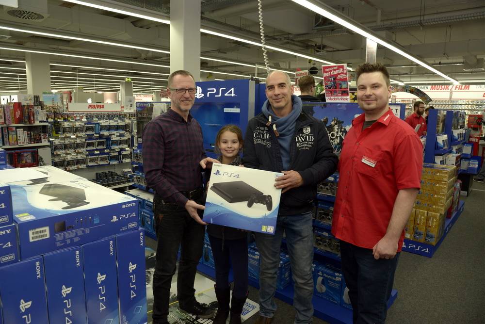  Uwe Samson (li.) und Christian Schmidt (re.) übergaben die Playstation an Gewinner Christoph Jost und Tochter Katharina. 