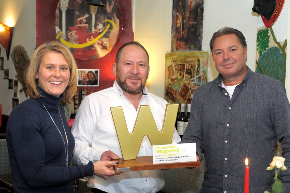  Hasan Aydin (Mitte) und sein „El Jamón“ gewinnen „Das Goldene W“ von „So schmeckt Wuppertal!“ in der Kategorie „Internationale Küche“. Die Jury-Auszeichnung überreichten „So schmeckt Wuppertal!“-Mediaberaterin Stefanie Pöller (links) und Redakteur Roderich Trapp. 
