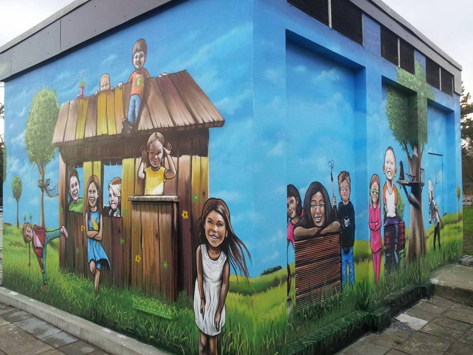  Zwei Seiten des bunten Graffiti-Trafohäuschens mit vielen Gesichtern der „PflanzBar“-Kids.  