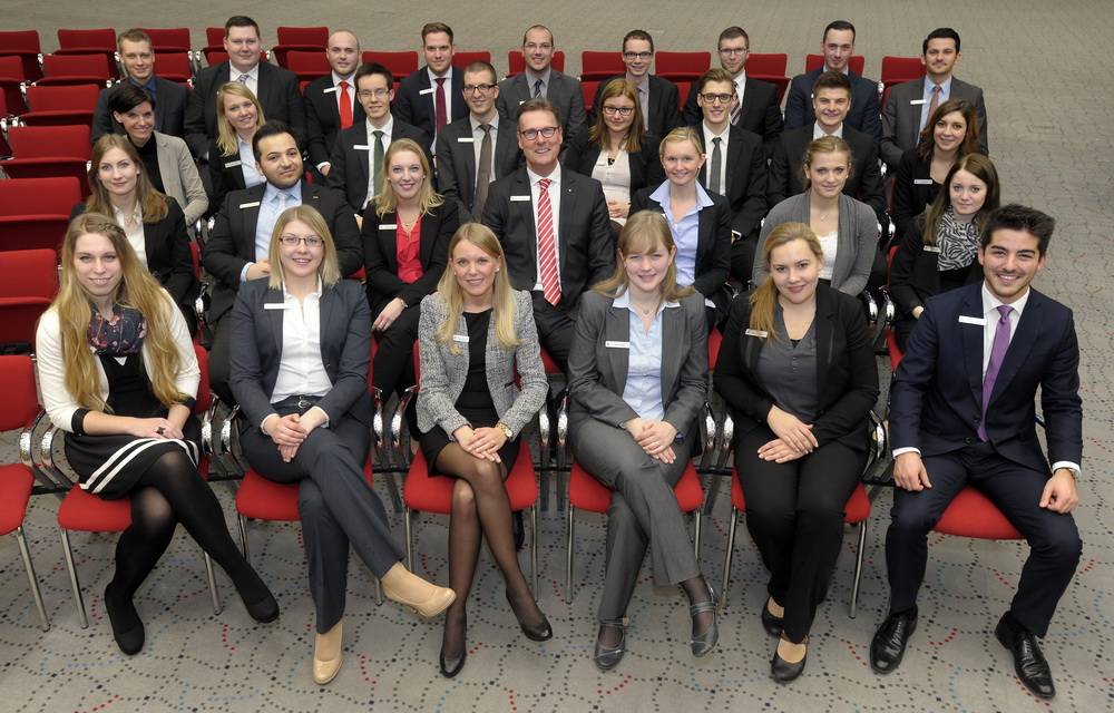  Gunther Wölfges und die Ausbildungsleiterin Julia Sander mit den 28 neuen Mitarbeiterinnen und Mitarbeitern. 