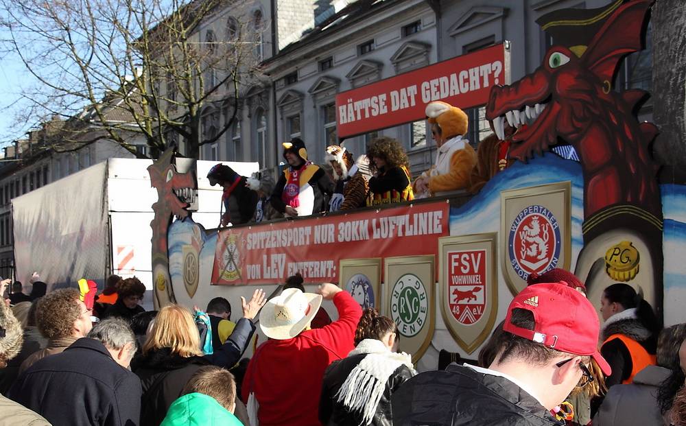  Replik beim Wuppertaler Rosensonntagszug auf die Werbekampagne des Fußball-Bundesligisten Bayer 04 Leverkusen: "Spitzensport nur 30 km Luftlinie von LEV entfernt - BHC, RSC, FSV, WSV." 