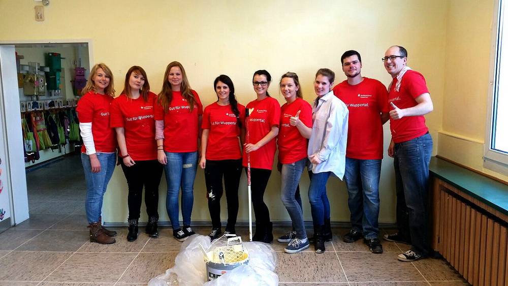  Gruppenbild mit Farbe: die sieben Auszubildenden und zwei Jugend- und Auszubildendenvertreter der Stadtsparkasse Wuppertal in der Kita Kyffhäuserstraße. 