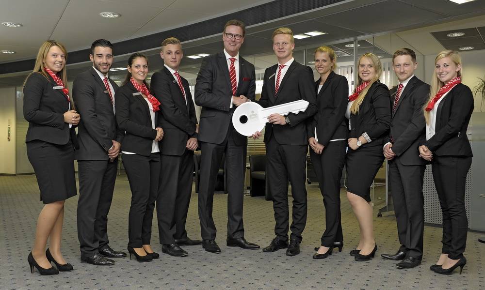  Die symbolische Schlüsselübergabe durch Gunther Wölfges, Vorstandsvorsitzender der Stadtsparkasse Wuppertal, mit den acht ausgewählten Auszubildenden und Mitarbeiterin Böckmann aus der Stammbesetzung der Filiale Rott. 