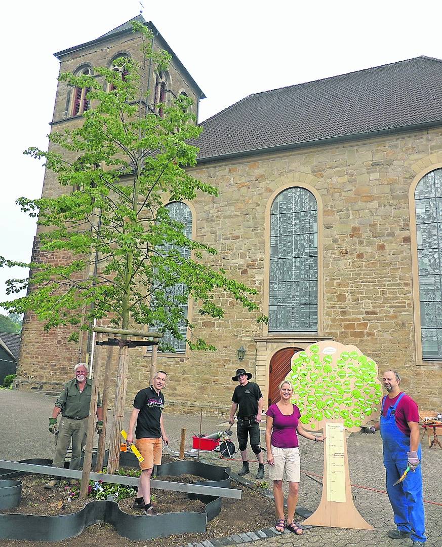  Das Spendenbarometer (r.) in Form eines Baumes ist fast am Ziel. Mitglieder der Gemeinde halfen Ralph Steigerwald beim Einbau einer Metalleinfassung für die künftige „begehbare Lutherrose“. 