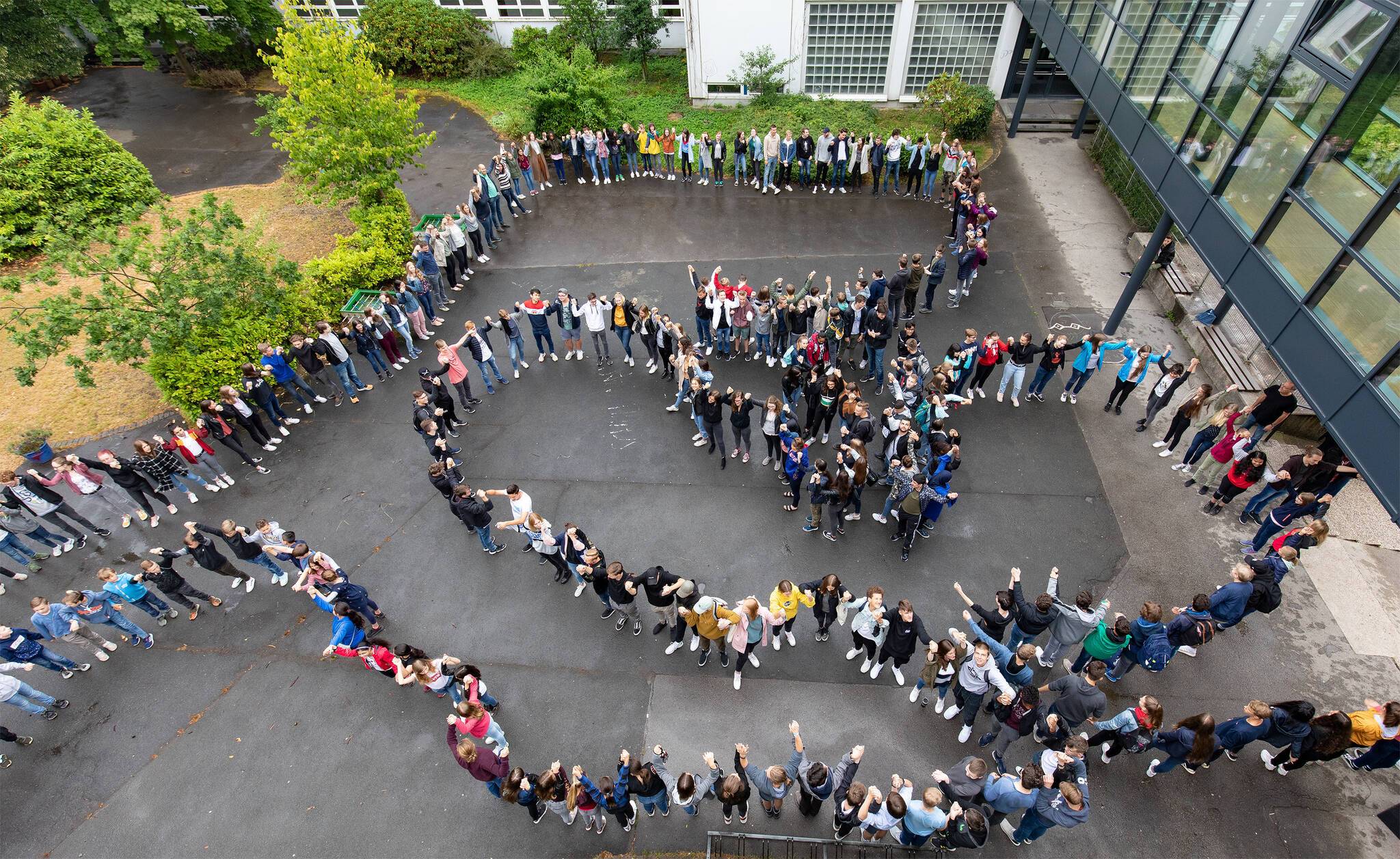  Sich an den Händen halten bilden die Schüler des Gymnasiums Bayreuther Straße eine Menschenkette gegen Abschiebung von Flüchtlingen.  