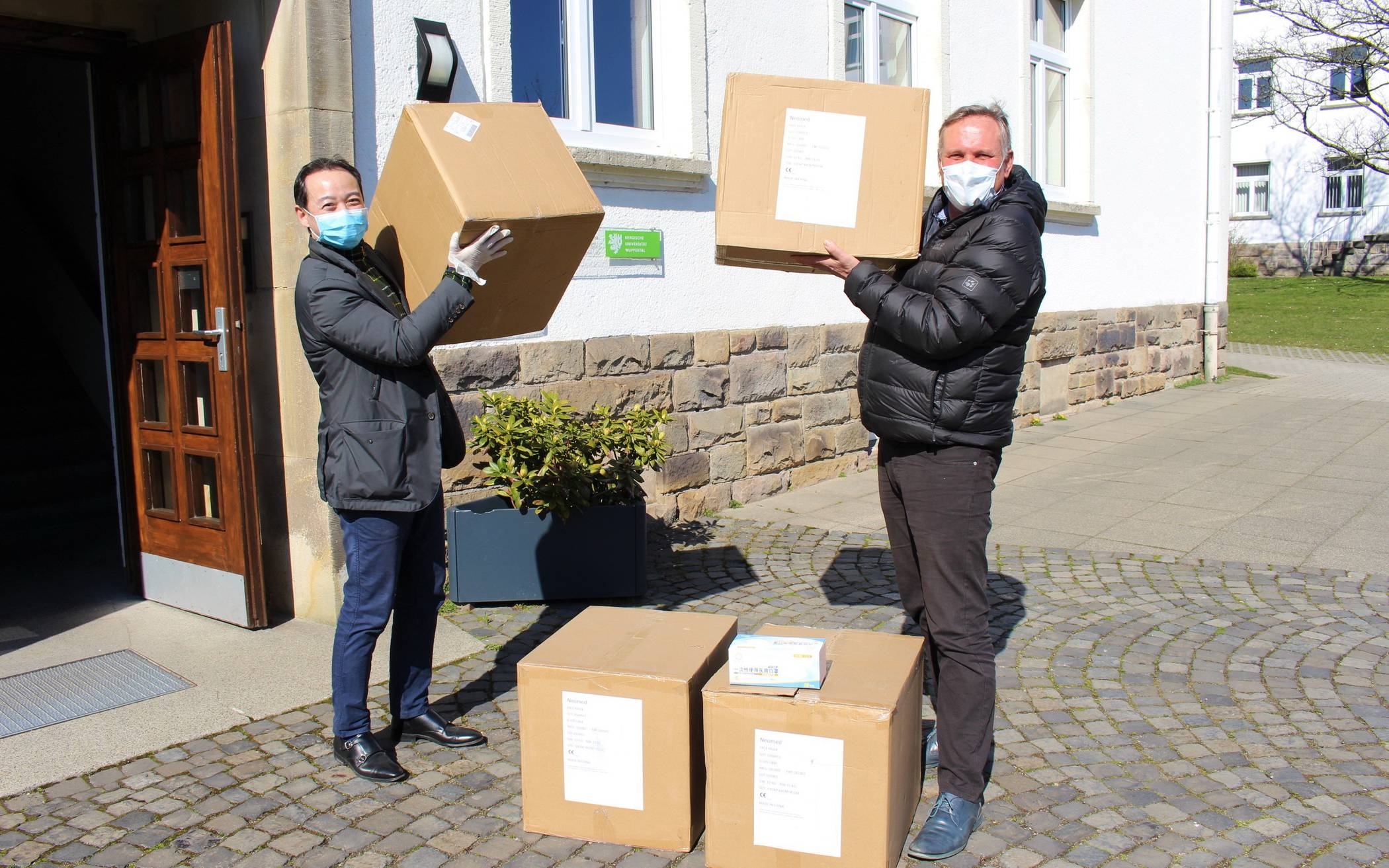  Qiang Rong (links), Chefrepräsentant der chinesischen Stadt Foshan, übergibt 10.000 Atemschutzmasken an Rolf Volmerig von der Wuppertaler Wirtschaftsförderung. 